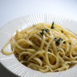 Pasta al limone con crema cremosa, decorata con scorza di limone fresco.