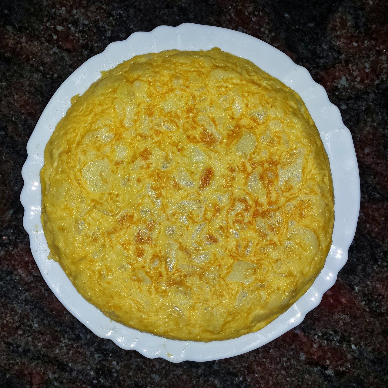 Frittata alta e soffice su un piatto, pronta per essere servita.